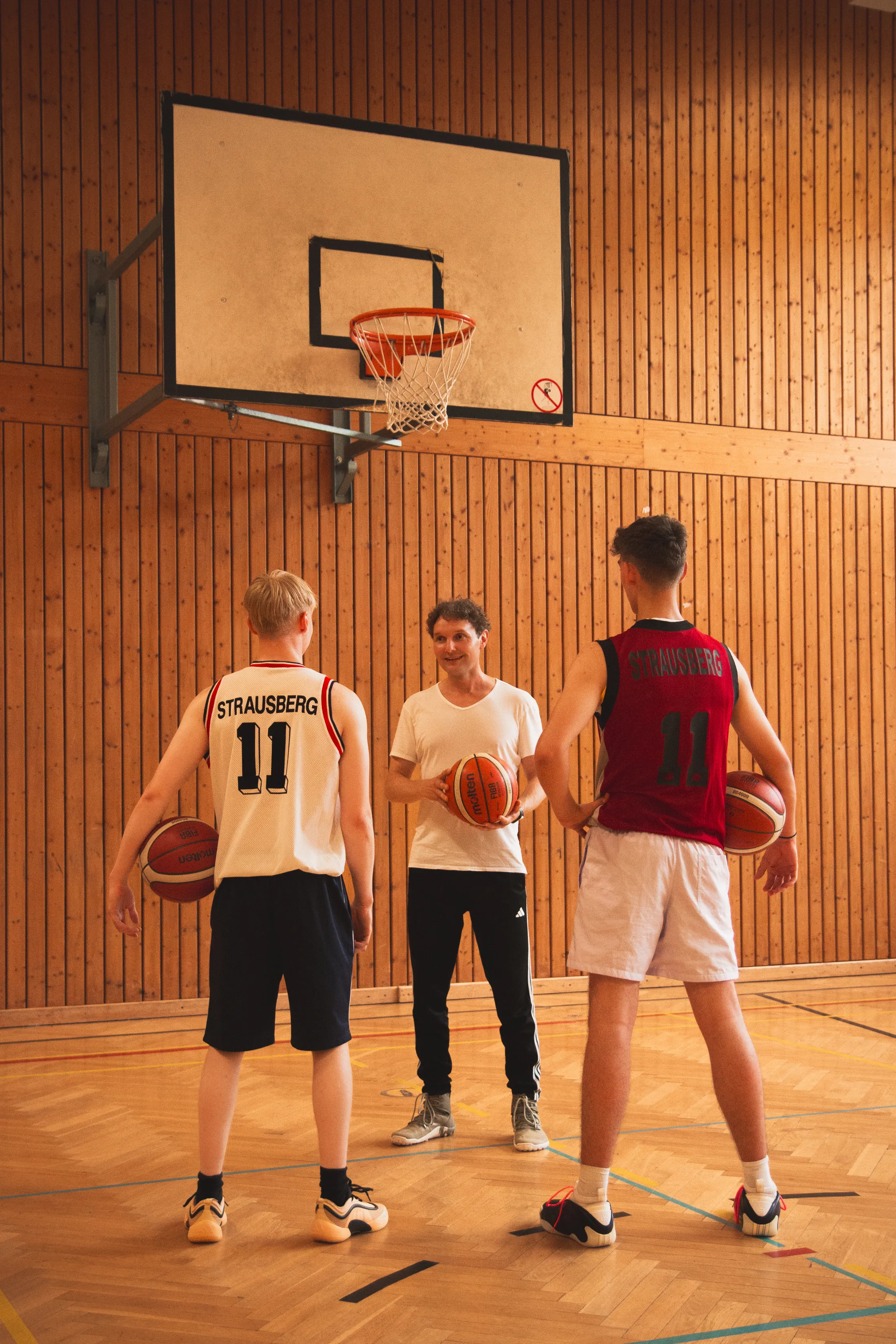 Trainer mit Jugendlichen beim Basketball-Training